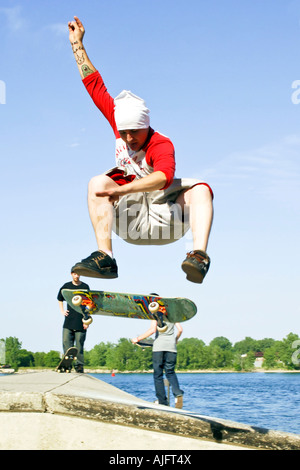 Teenage pratiche maschio salta trucchi e maneouvers su uno skateboard Foto Stock