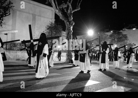 Righe di penitenti durante le processioni della Settimana Santa a Siviglia Spagna Foto Stock
