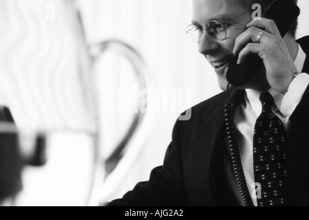 Foto in bianco e nero di un imprenditore caucasico parlando al telefono in sala conferenze Foto Stock