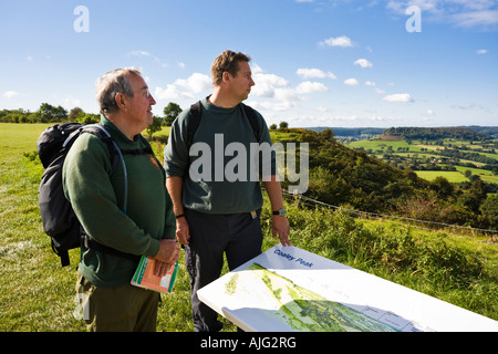 Due escursionisti sulla Cotswold modo godendo della vista sul Severn Vale dal picco Coaley Picnic. Gloucestershire Foto Stock