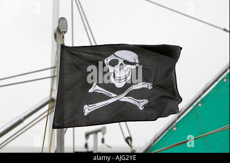 Cranio e crossbones battenti bandiera dal montante della barca a vela ormeggiata in Kilkeel Harbour contea di Down Irlanda del Nord Foto Stock