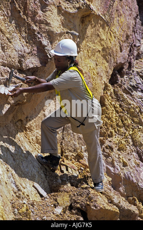 Donna del geologo esaminando roccia sulla miniera d'oro, Guinea, Africa occidentale Foto Stock