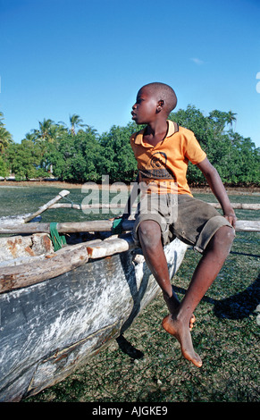 Tanzania, ragazzo seduto su di una piroga Utende Mafia sud dell'isola di Zanzibar e Tanzania Africa Foto Stock