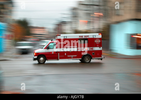 Ambulanza correre attraverso le strade della città Foto Stock