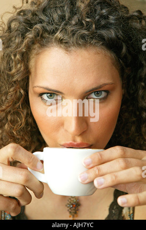 Giovane donna godere di cappuccino in un cafe ritratto Foto Stock