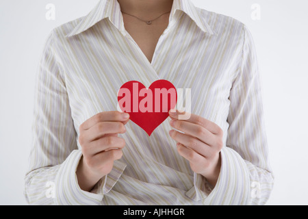 Imprenditrice tenendo a forma di cuore la carta Foto Stock