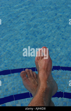 Relax piedini maschio immersione nella piscina esterna Foto Stock