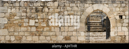 Il vecchio muro di pietra con un andamento arcuato porta aperta Foto Stock