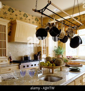 Cucina con piano in marmo di superficie e pentole appese cucina puleggia di cameriera. Foto Stock