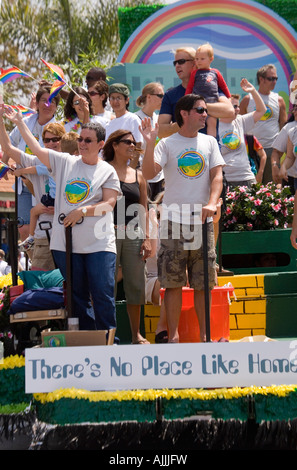 I partecipanti in San Diego's annuan Gay Pride Parade onda per la folla di spettatori da loro galleggiante colorato. Foto Stock