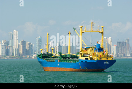 Una grande nave ancorata con lo skyline della città di Panama in aumento in background. Foto Stock