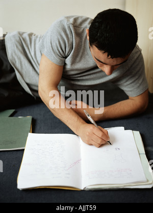 Ragazzo adolescente facendo i compiti di scuola Foto Stock