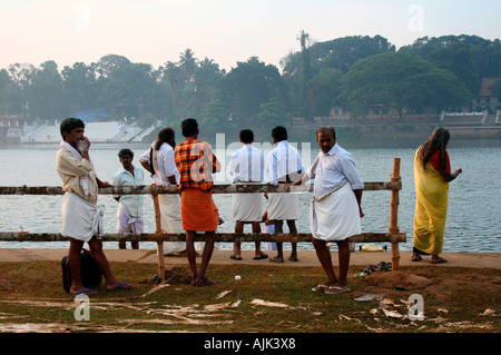 Persone in piedi prima della balneazione ghat nei pressi di un tempio ad Aluva, Kerala Foto Stock