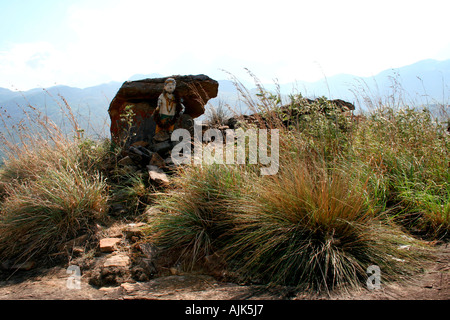 Una vecchia statua di una divinità tribali collocato accanto ad una roccia sulla cima di una collina, Marayoor, Kerala, India Foto Stock