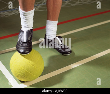 Il calciatore in piedi sul calcio Foto Stock