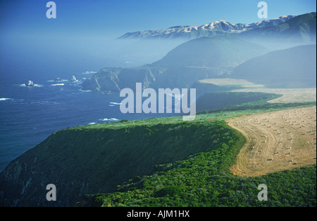 Big Sur Coast in California centrale a sunrise guardando attraverso terreni coltivati e colline nebbiose della costiera mountain range Foto Stock