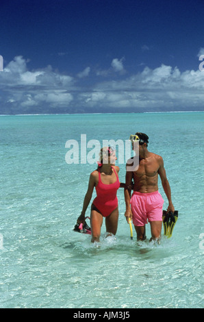 Giovane indossando maschere per lo snorkeling e le pinne a piedi in acqua poco profonda in laguna a Matira Beach Bora Bora Polinesia Francese Foto Stock