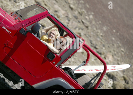 Una giovane coppia in vacanza con la jeep e tavole da surf, Spagna, Canarie, Lanzarote Foto Stock