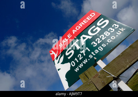 Una proprietà in vendita convenuto segno sulla strada di un paese rurale in Devon Foto Stock