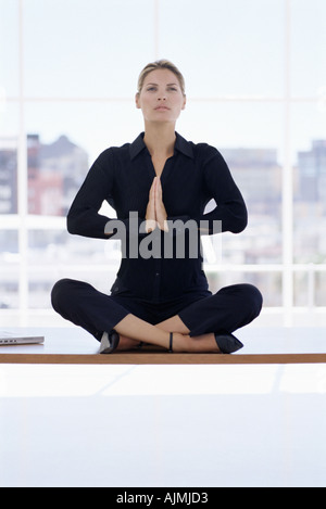 Donna meditando sulla sua scrivania Foto Stock