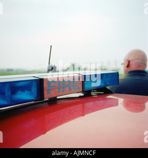 Vigile del fuoco nei pressi di automobile Foto Stock