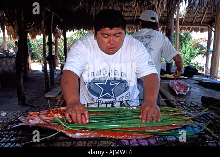 I messicani preparazione del pesce a servire per i turisti che visitano la Isla Contoy parco nazionale e il santuario degli uccelli vicino a Cancun in Messico. Foto Stock