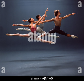 Tre ballerini eseguono un grand jete in studio Foto Stock