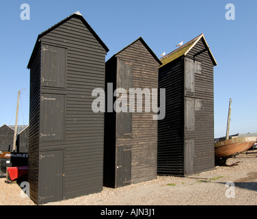 Net negozi questi elementi distintivi e storico meteo alto imbarcato in asfalto nero capanne sul bordo della spiaggia sono stati usati per asciugare fishi Foto Stock