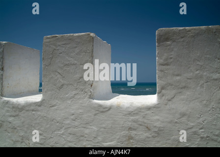 Guardando fuori sull'Oceano Atlantico all'orizzonte attraverso la sommità della merlata parete dipinta di bianco della Medina. Foto Stock