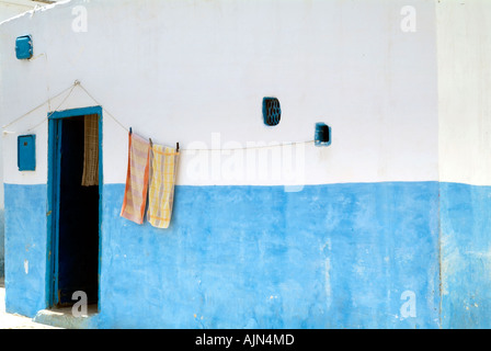 Due asciugamani appeso su una linea al di fuori di un blu e imbiancato casa nella Medina di Asilah Foto Stock