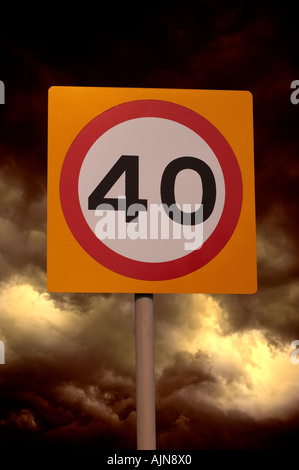 Quaranta miglia di un'ora limite velocità su strada segno con cielo tempestoso sfondo Foto Stock
