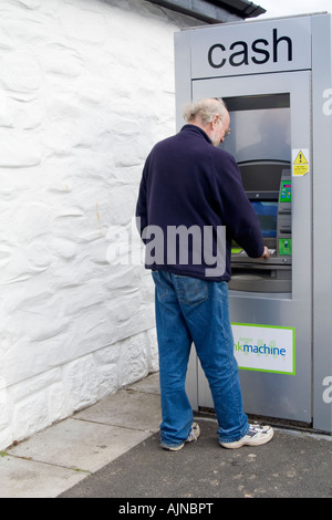 Uomo che utilizza un bancomat Foto Stock