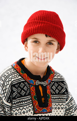 Ritratto di soggetti di razza caucasica ragazzo che indossa un maglione rosso e Cappello invernale sorridente al viewer Foto Stock