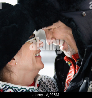 Vista laterale ravvicinata di un mezzo caucasici di età compresa tra uomo e donna con le loro teste toccando guardando ogni altra sorridente Foto Stock