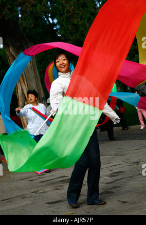 Donna facendo esercizio mattutino con nastro presso il Tempio del Cielo a Pechino in Cina Foto Stock