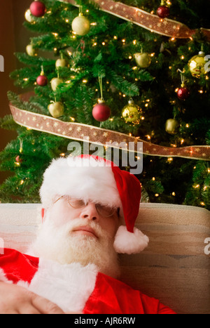 Santa Claus, addormentato nella parte anteriore dell albero di Natale Foto Stock