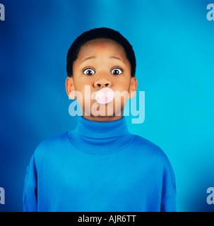 Un ragazzo soffiando una bolla Foto Stock