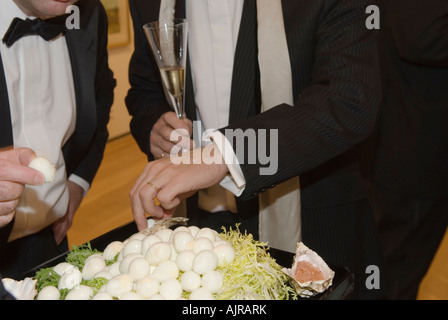 Finger food quaglie uova sbucciate, ricevimento con champagne, evento Black tie cena di beneficenza formale Londra 2007 Inghilterra 2000 UK HOMER SYKES Foto Stock