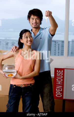 Ritratto di un giovane uomo che mostra una chiave ad una giovane donna Foto Stock