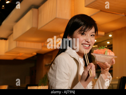 Ritratto di una imprenditrice tenendo una ciotola di sushi Foto Stock