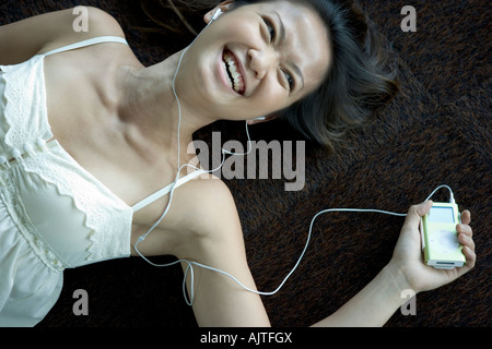 Angolo di alta vista di una giovane donna di ascolto di un lettore MP3 Foto Stock