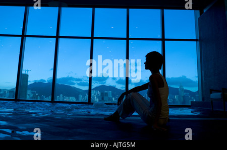 Silhouette di una donna seduta vicino ad una vasca calda Foto Stock