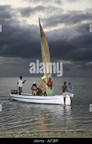 Musicista africano a suonare le percussioni in barca da pesca Foto Stock