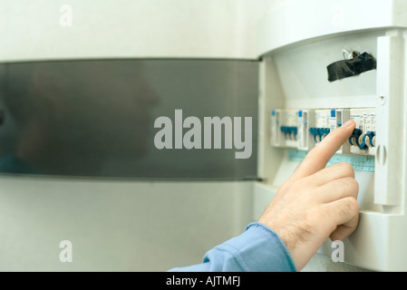 L'uomo la commutazione il fusibile nella scatola dei fusibili, close-up di mano Foto Stock