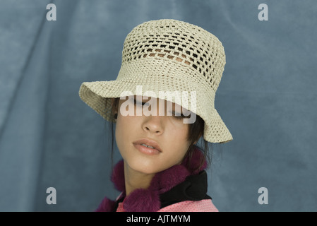 Ragazza adolescente indossando cappello per il sole, guardando verso il basso, verticale Foto Stock