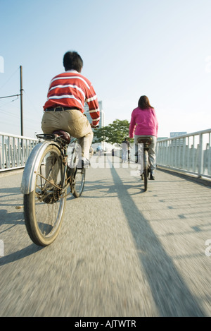 I ciclisti attraversando il ponte, vista posteriore Foto Stock