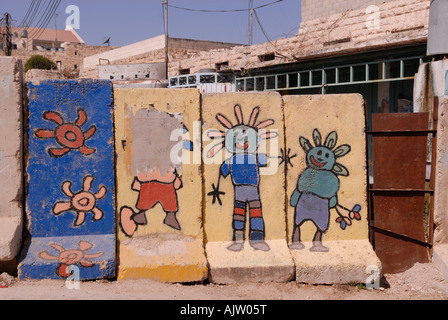 Graffiti decorano le lastre di cemento che separa israeliani e palestinesi in aree della città divisa di Hebron in Cisgiordania Israele Foto Stock