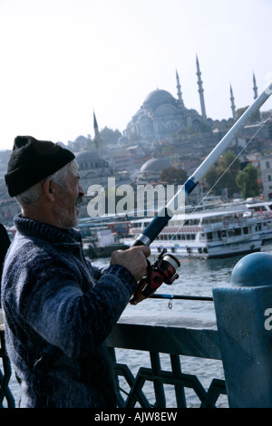 La pesca dal Ponte Galata con la Moschea di Suleymaniye e Eminonu in background, Istanbul, Turchia Foto Stock
