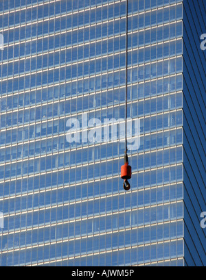 Una gru-gancio appeso davanti di un grattacielo Foto Stock