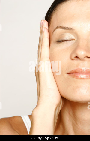 Giovane donna con la mano sulla faccia Foto Stock